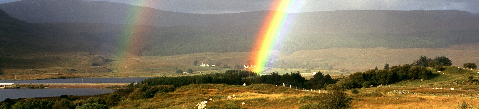 Double rainbows over a hillside