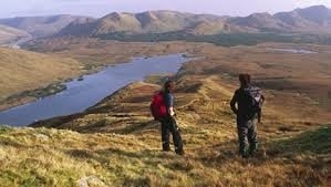 hikers looking over stream and hills