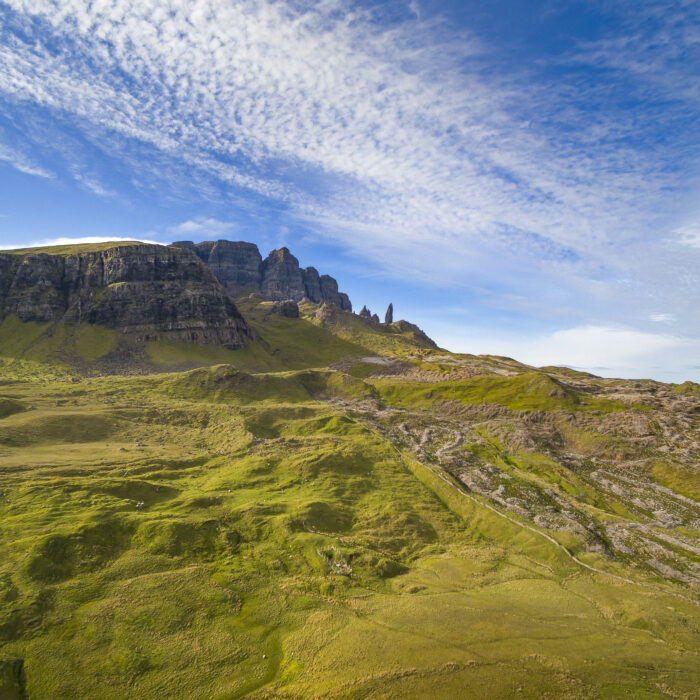 The iconic Old Man of Storr, a majestic rock formation on the Isle of Skye, Scotland, standing amidst rugged landscape and misty hills, a popular hiking destination.